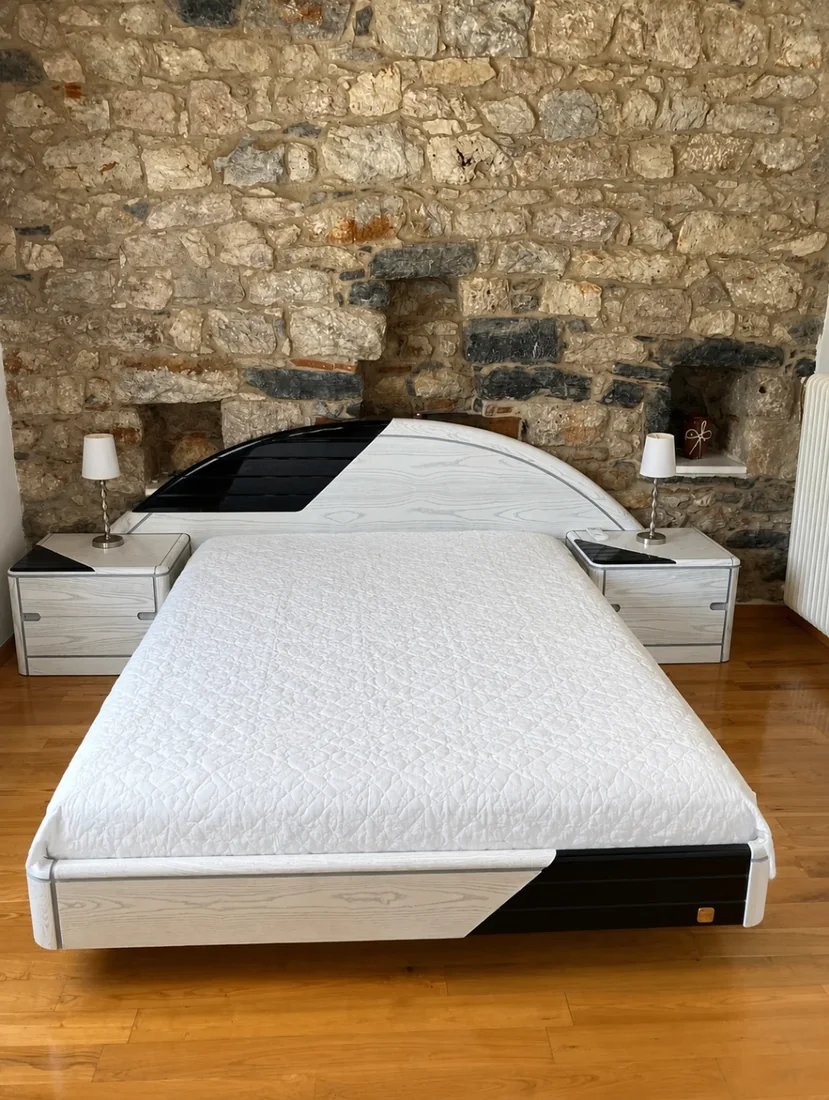 Double bed in a stone-walled bedroom at Villa Arcadia